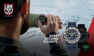 Person holding a LUMINOX watch with promotional text 'Every Second Counts' against a snowy landscape.